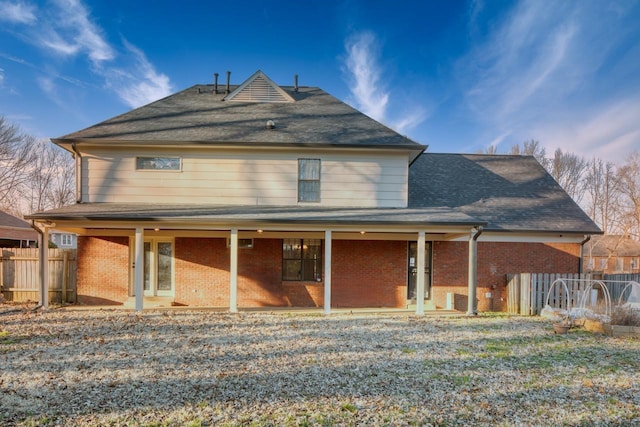 back of property with fence and brick siding