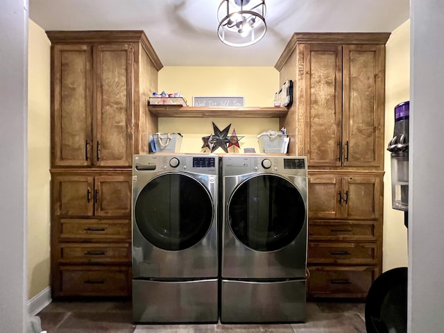 clothes washing area with a notable chandelier, independent washer and dryer, cabinet space, and baseboards