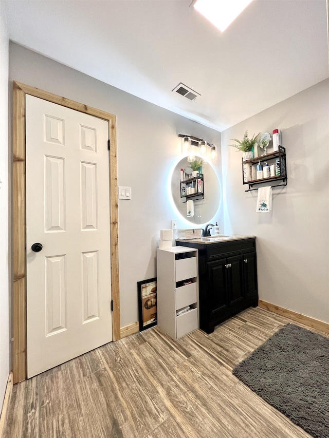 bar with light wood finished floors, visible vents, and baseboards