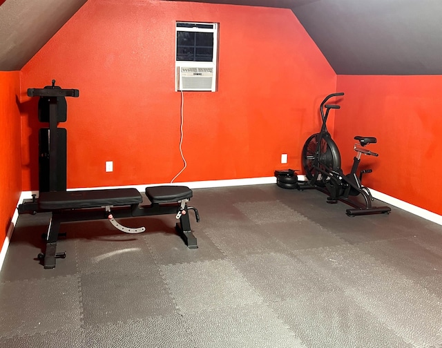 workout room featuring baseboards and vaulted ceiling