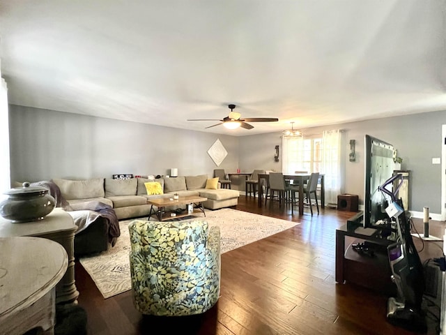 living area with dark wood-type flooring, ceiling fan, and baseboards