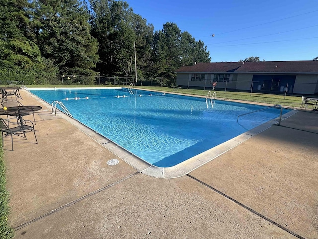 community pool with fence, a patio, and a yard