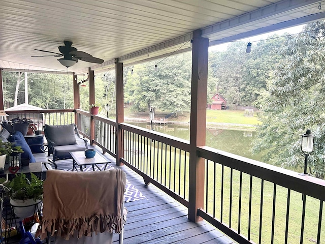 wooden terrace with ceiling fan and a yard