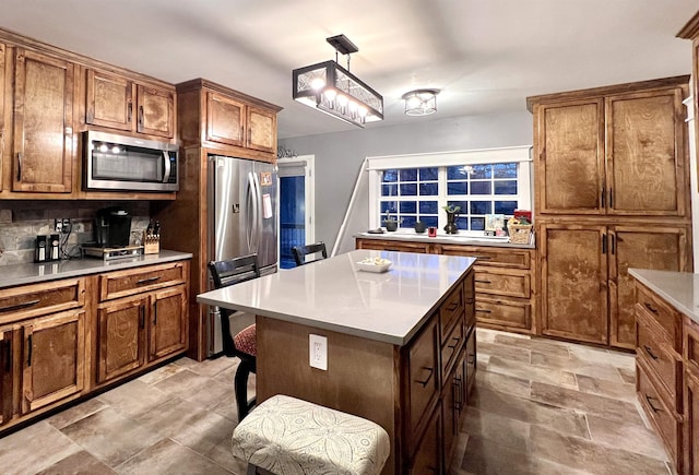 kitchen featuring stainless steel appliances, stone finish floor, and brown cabinetry