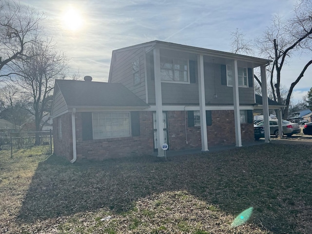 view of front of property with brick siding and fence