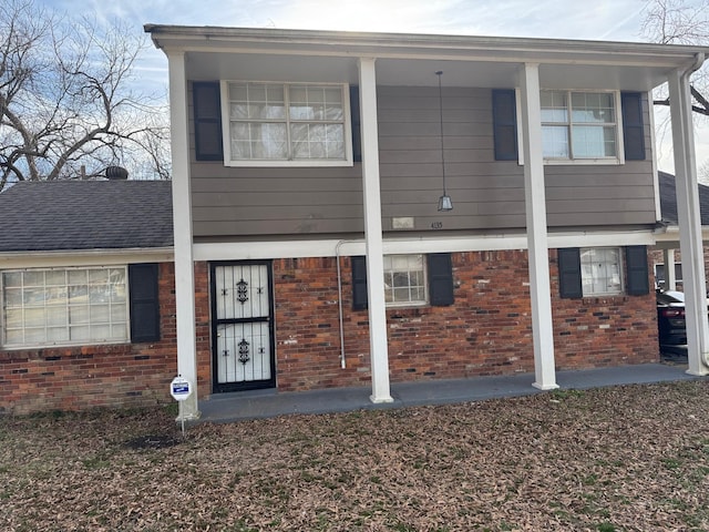 view of front of property with brick siding and roof with shingles