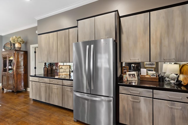 kitchen featuring dark countertops, ornamental molding, dark wood-style flooring, and freestanding refrigerator