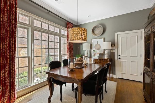 dining area featuring crown molding and wood finished floors