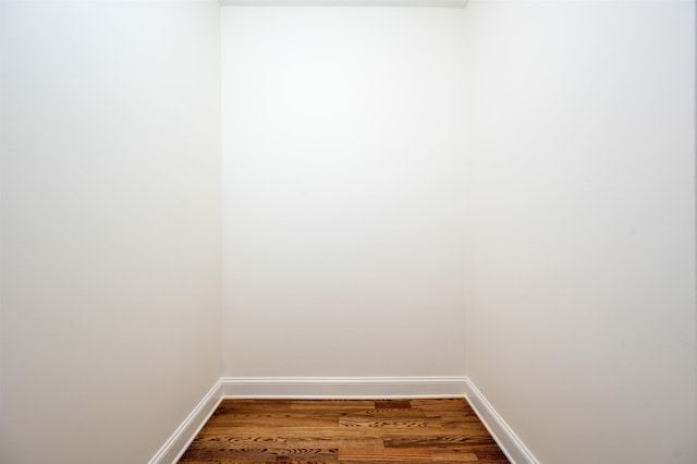 walk in closet with dark wood finished floors