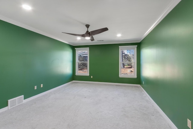 unfurnished room featuring a ceiling fan, visible vents, baseboards, carpet, and crown molding