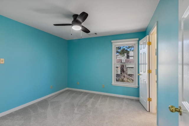 unfurnished bedroom featuring baseboards, visible vents, a ceiling fan, and light colored carpet