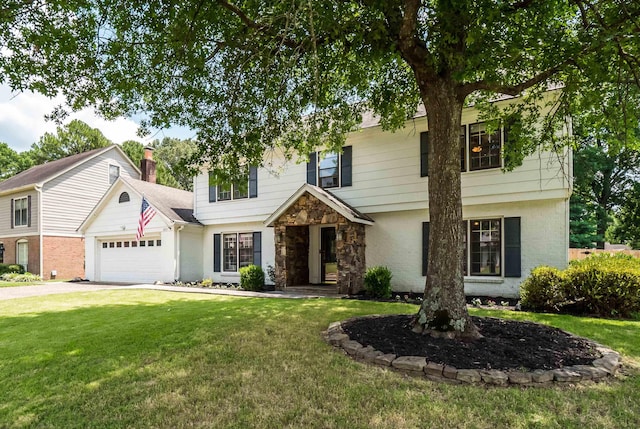 colonial-style house featuring a garage, driveway, stone siding, and a front yard