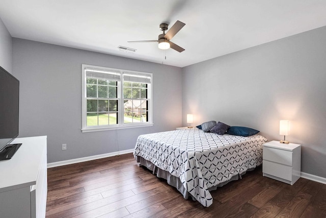 bedroom featuring dark wood-style floors, ceiling fan, visible vents, and baseboards