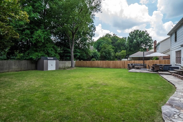 view of yard featuring a fenced backyard, a shed, a patio, and an outdoor structure