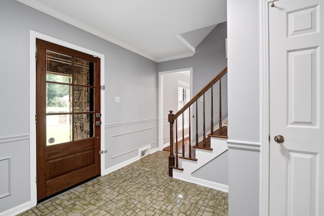 foyer entrance with a wainscoted wall, stairs, a decorative wall, and crown molding