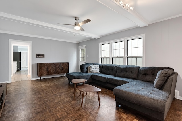 living area with ceiling fan, baseboards, and beamed ceiling