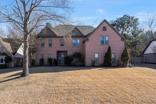 traditional home with a front yard and brick siding