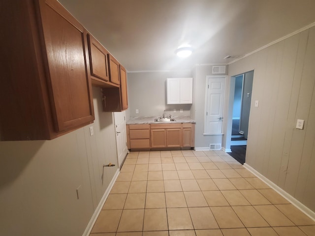 kitchen featuring visible vents, ornamental molding, light countertops, and a sink