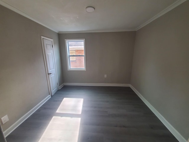 unfurnished room featuring dark wood-style floors, ornamental molding, and baseboards