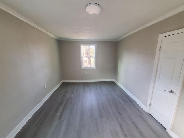 empty room with baseboards, dark wood-style flooring, and ornamental molding