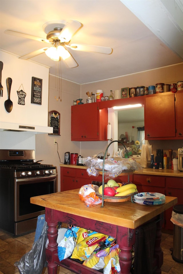 kitchen with a ceiling fan, light countertops, stainless steel gas stove, and under cabinet range hood