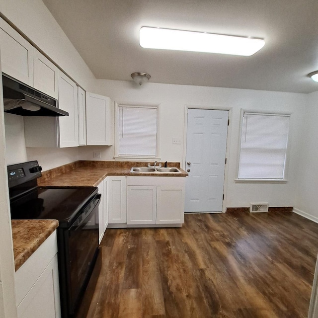 kitchen featuring white cabinetry, under cabinet range hood, black / electric stove, a sink, and dark wood-style floors