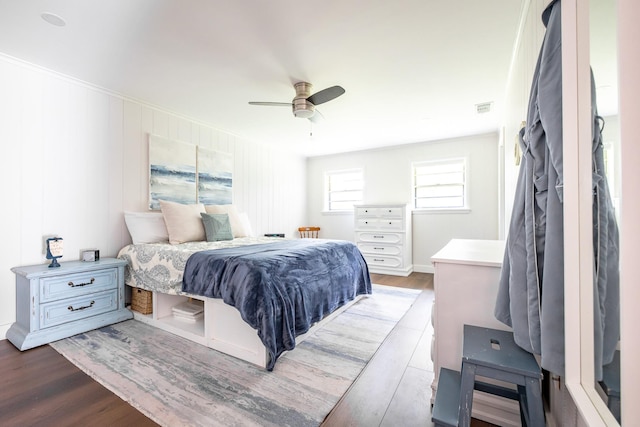 bedroom with ceiling fan, wood finished floors, and visible vents