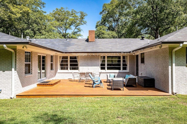 rear view of property featuring a yard, a chimney, and brick siding