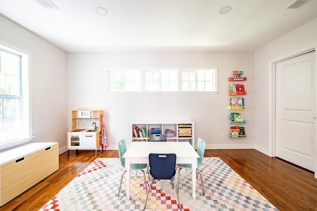 playroom featuring wood finished floors, visible vents, and baseboards