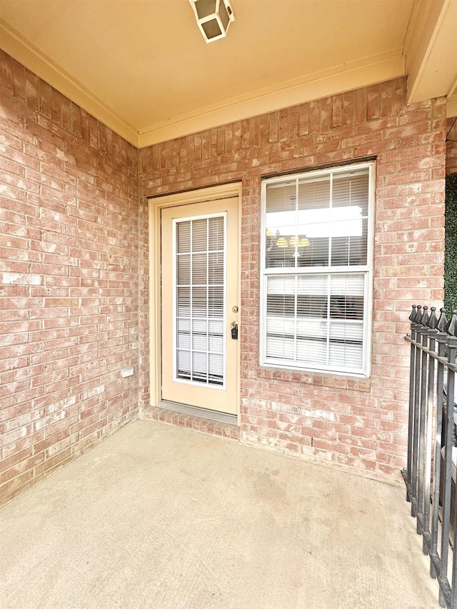 entrance to property featuring brick siding