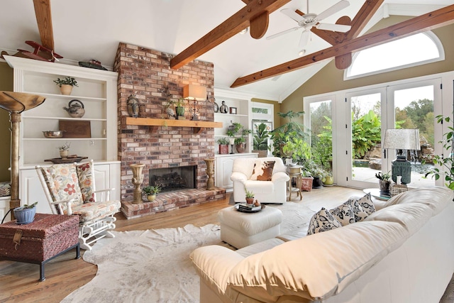 living room featuring beamed ceiling, wood finished floors, built in shelves, high vaulted ceiling, and a fireplace