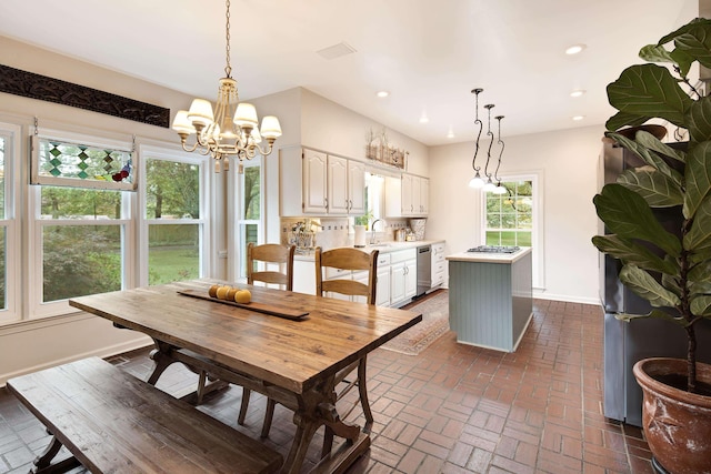 dining room with brick floor, recessed lighting, a notable chandelier, and baseboards