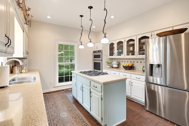 kitchen featuring stainless steel appliances, recessed lighting, backsplash, a sink, and a kitchen island