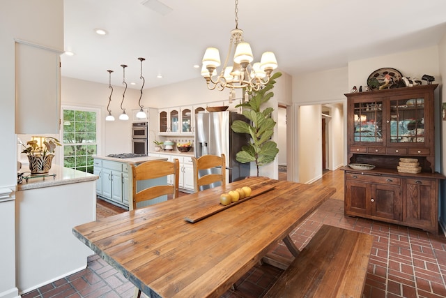 dining room featuring brick floor, recessed lighting, and a notable chandelier