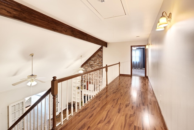 hall featuring attic access, baseboards, wood finished floors, vaulted ceiling with beams, and an upstairs landing