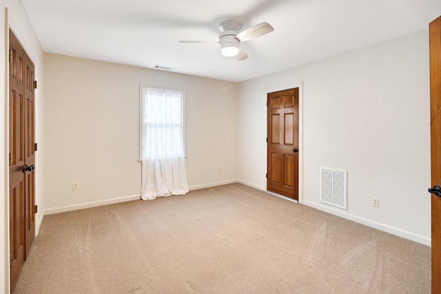 empty room featuring visible vents, light carpet, and baseboards