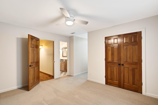 bedroom with light colored carpet, ceiling fan, visible vents, and baseboards