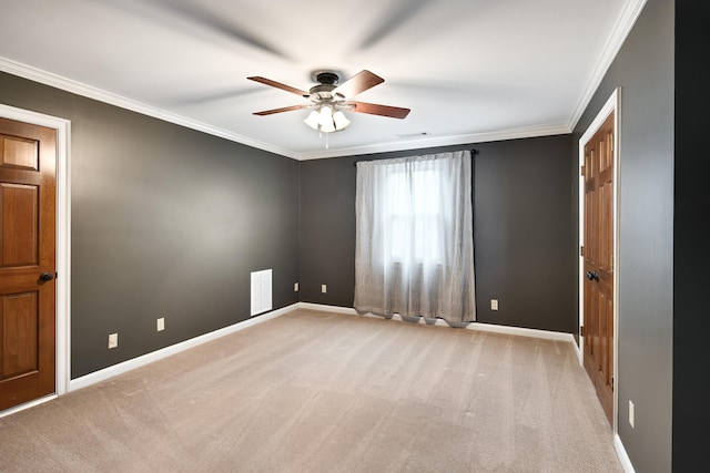 spare room featuring carpet floors, ornamental molding, and baseboards