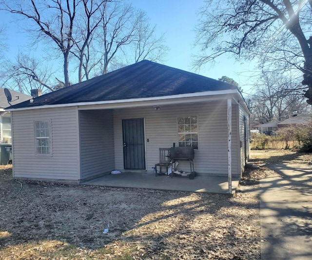 rear view of property featuring roof with shingles