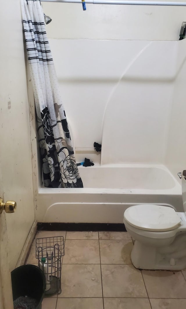 full bath with toilet, tile patterned flooring, and shower / tub combo with curtain