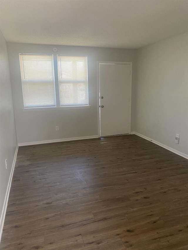 foyer entrance featuring dark wood-type flooring and baseboards