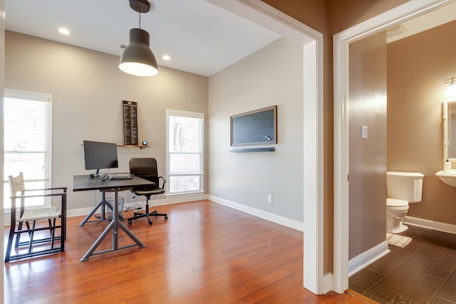 office space featuring recessed lighting, plenty of natural light, wood finished floors, and baseboards