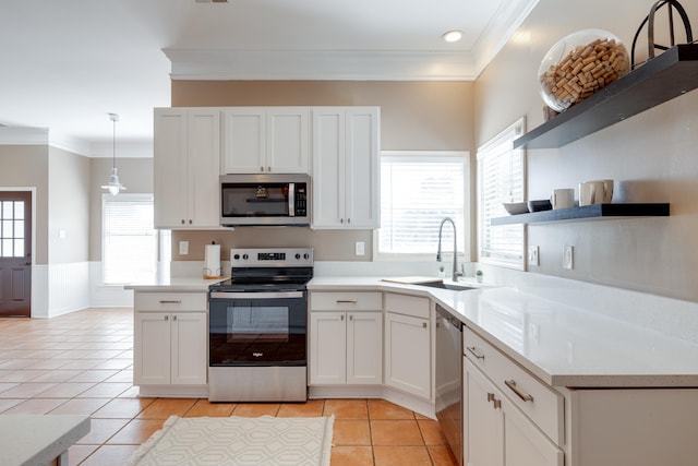 kitchen featuring light tile patterned floors, a sink, appliances with stainless steel finishes, ornamental molding, and open shelves