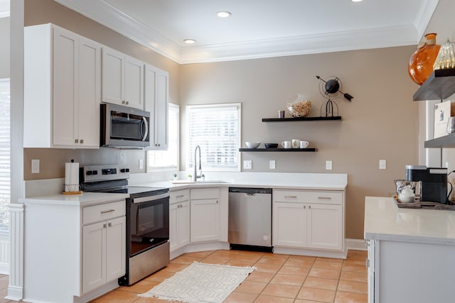 kitchen with ornamental molding, stainless steel appliances, open shelves, and a sink