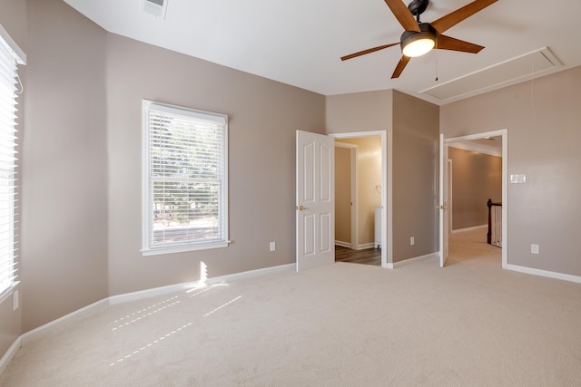 unfurnished bedroom with attic access, baseboards, ceiling fan, and carpet flooring