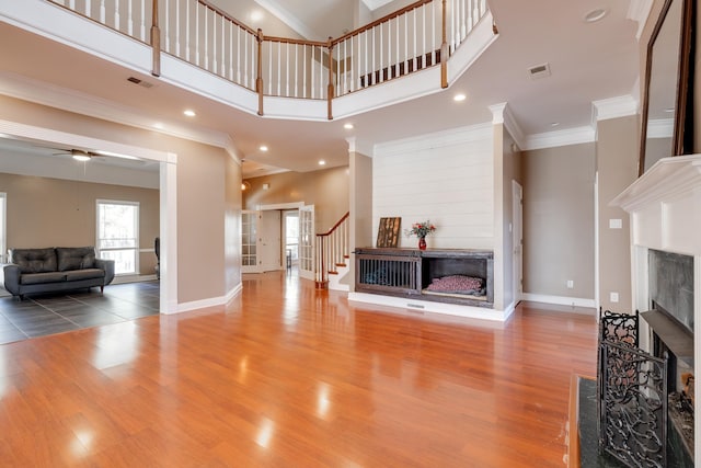 living area with a fireplace, wood finished floors, and visible vents