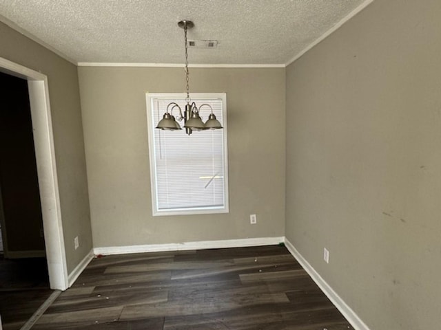 unfurnished dining area with dark wood-type flooring, a textured ceiling, baseboards, and an inviting chandelier