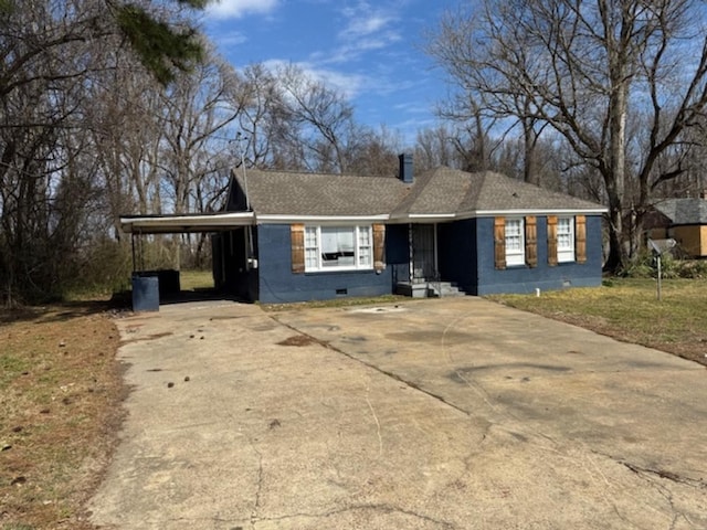 single story home with a shingled roof, crawl space, an attached carport, driveway, and a front lawn