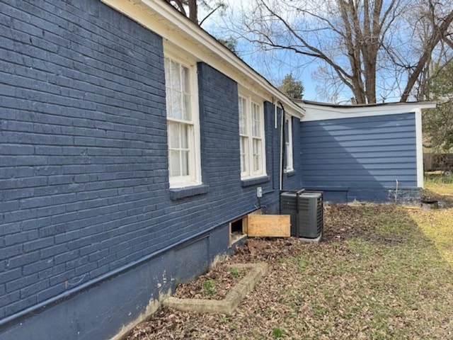 view of side of property featuring brick siding and cooling unit