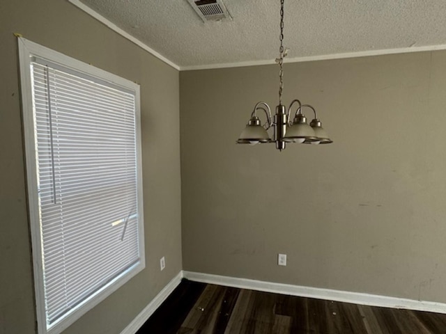 unfurnished dining area featuring baseboards, visible vents, dark wood-type flooring, a textured ceiling, and a chandelier